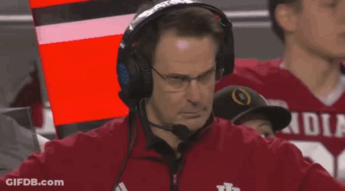 A Man Wearing Headphones And A Red Jacket That Says Indiana GIF