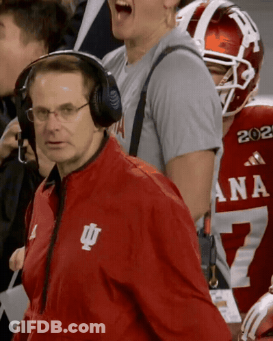 A Man Wearing Headphones And A Red Jacket With The Letters Iu On It GIF