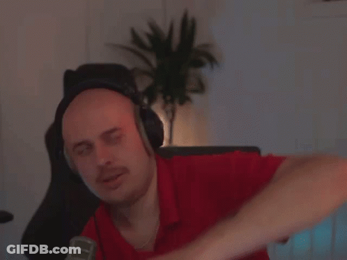 A Man Wearing Headphones And A Red Shirt Is Sitting In Front Of A Microphone GIF