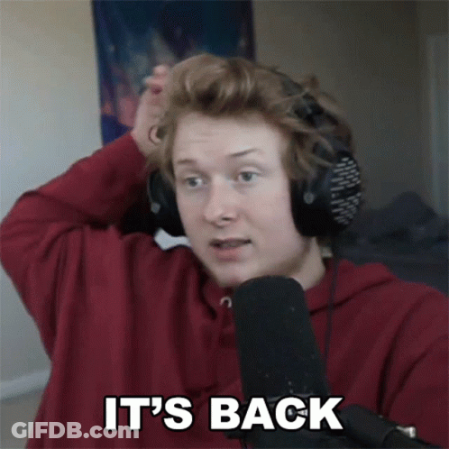 A Man Wearing Headphones And A Red Shirt Says It 'S Back In Front Of A Microphone GIF
