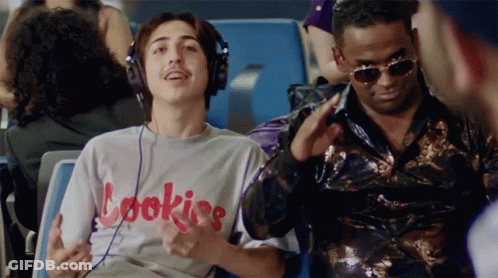 A Man Wearing Headphones And A Shirt That Says Cookies Is Sitting Next To Another Man GIF