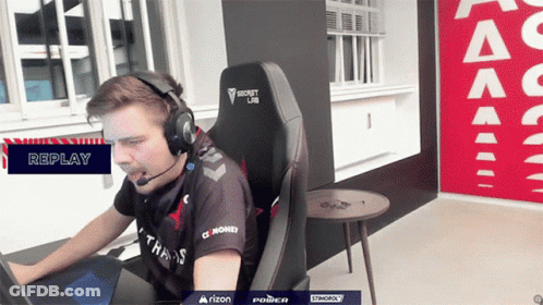 A Man Wearing Headphones And A Shirt That Says Money Is Sitting In A Chair GIF