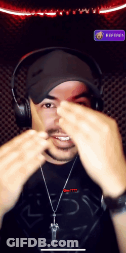 A Man Wearing Headphones And A Shirt That Says Superman Is Making A Face GIF
