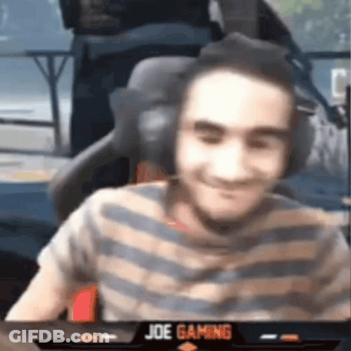 A Man Wearing Headphones And A Striped Shirt Is Smiling While Sitting In A Chair . GIF