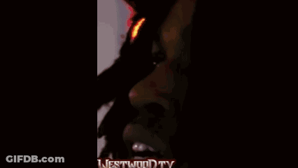 A Man Wearing Headphones And A Superman Shirt Is Standing In Front Of A Microphone With The Words Westwood Tv On The Bot GIF