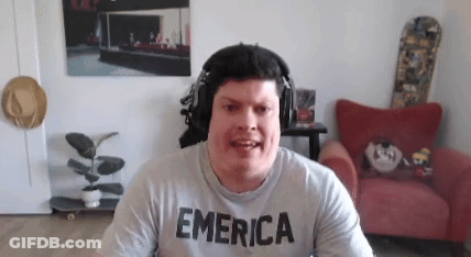 A Man Wearing Headphones And A T-Shirt That Says Emerica Is Sitting In A Living Room . GIF