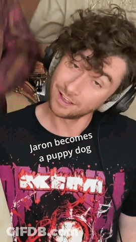 A Man Wearing Headphones And A T-Shirt That Says Jaron Becomes A Puppy Dog GIF