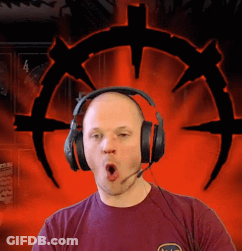 A Man Wearing Headphones And A T-Shirt With The Letter S On It Makes A Funny Face GIF