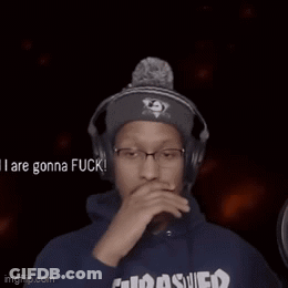A Man Wearing Headphones And A Thrasher Hoodie Is Sticking Out His Tongue . GIF
