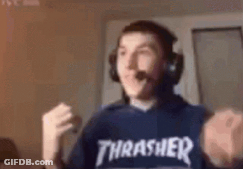 A Man Wearing Headphones And A Thrasher T-Shirt Is Sitting In Front Of A Computer . GIF