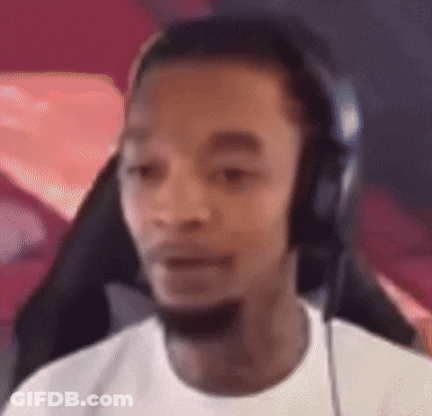 A Man Wearing Headphones And A White Shirt Is Looking At The Camera . GIF