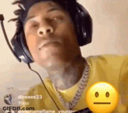 A Man Wearing Headphones And A Yellow Shirt Has A Smiley Face On His Chest . GIF