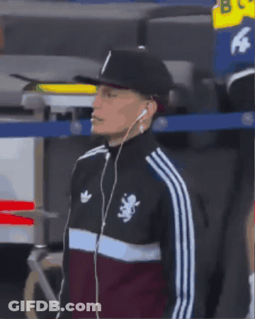 A Man Wearing Headphones And An Adidas Jacket With A Lion On The Front GIF