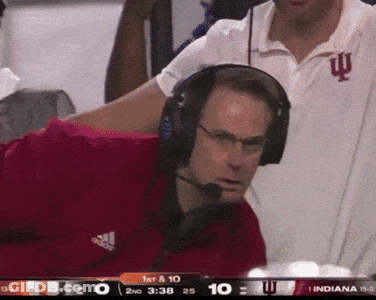 A Man Wearing Headphones And An Adidas Shirt Is Watching A Game GIF