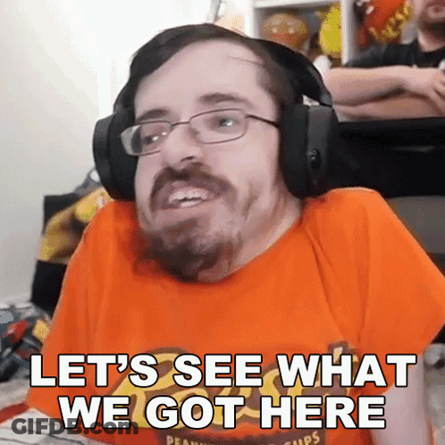 A Man Wearing Headphones And An Orange Shirt With The Words Let 'S See What We Got Here GIF