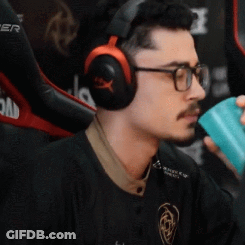 A Man Wearing Headphones And Glasses Is Holding A Blue Cup GIF