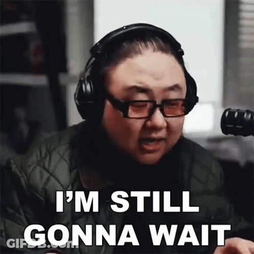A Man Wearing Headphones And Glasses Is Saying " I 'M Still Gonna Wait " GIF