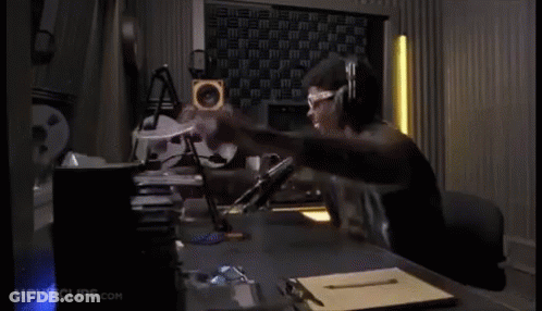 A Man Wearing Headphones And Glasses Is Sitting At A Desk In A Room With Movieclips.com On The Bottom Of The Screen GIF