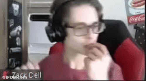 A Man Wearing Headphones And Glasses Is Sitting In Front Of A Coca Cola Sign . GIF