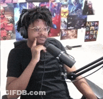 A Man Wearing Headphones And Glasses Is Sitting In Front Of A Microphone .. GIF