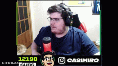 A Man Wearing Headphones And Glasses Is Sitting In Front Of A Microphone With The Number 12198 In The Corner GIF
