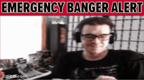 A Man Wearing Headphones And Glasses Is Smiling In Front Of A Sign That Says Emergency Banger Alert GIF