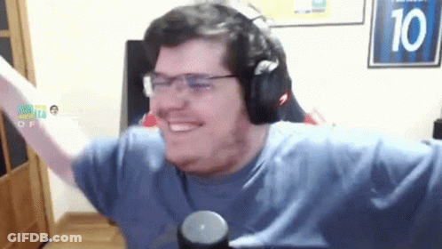 A Man Wearing Headphones And Glasses Is Smiling In Front Of A Sign With The Number 10 On It GIF