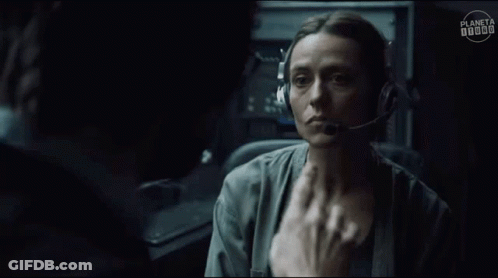 A Man Wearing Headphones And Glasses Is Talking To A Woman In A Dark Room . GIF