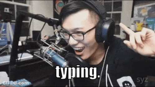 A Man Wearing Headphones And Glasses Is Typing In Front Of A Microphone GIF
