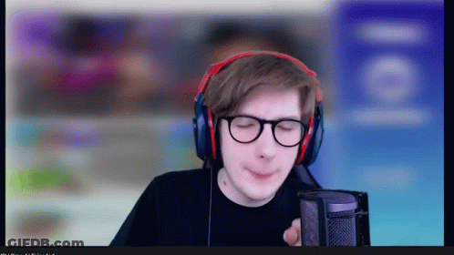 A Man Wearing Headphones And Glasses Looks At The Camera GIF