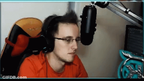 A Man Wearing Headphones And Glasses Sitting In Front Of A Microphone . GIF