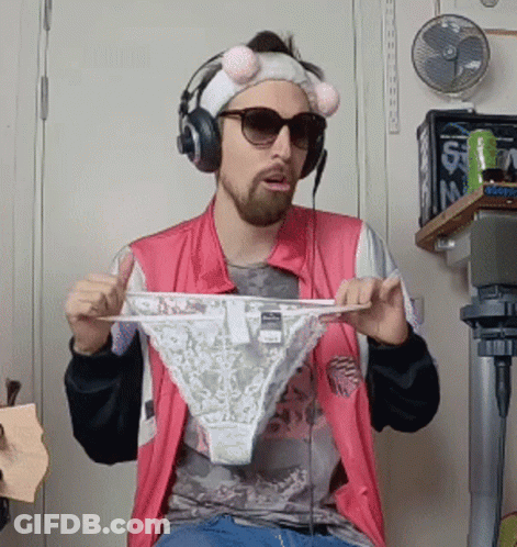 A Man Wearing Headphones And Sunglasses Is Holding Up A Pair Of Underwear GIF