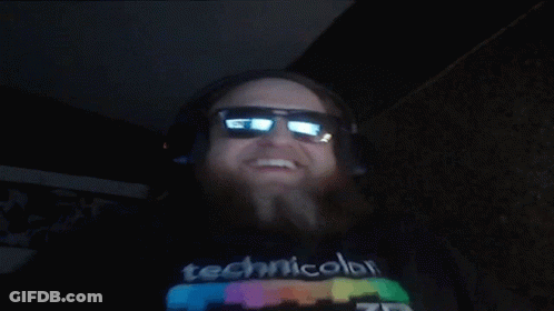 A Man Wearing Headphones And Sunglasses Is Wearing A Technicolor T-Shirt GIF