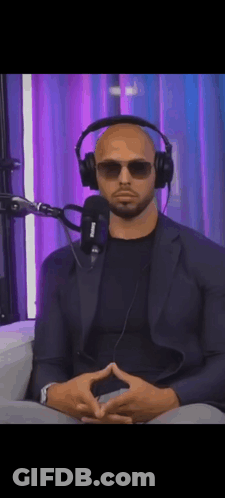 A Man Wearing Headphones And Sunglasses Sitting In Front Of A Microphone . GIF