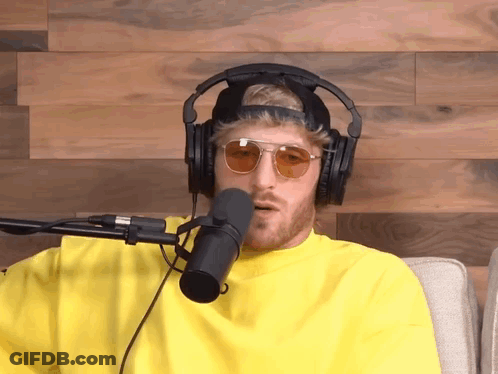 A Man Wearing Headphones And Sunglasses Talking Into A Microphone GIF
