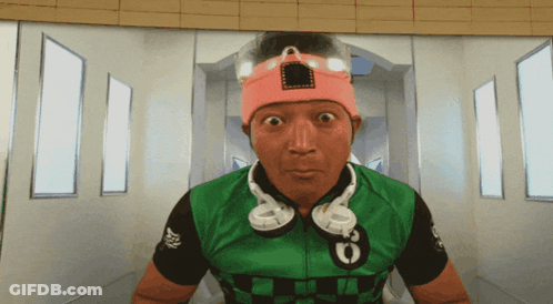 A Man Wearing Headphones Around His Neck And A Pink Headband With The Number 6 On It GIF