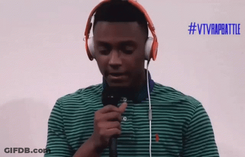 A Man Wearing Headphones Holds A Microphone In Front Of A #Vtvrapbattle Sign GIF
