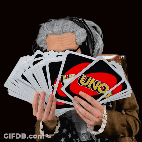 A Man Wearing Headphones Holds A Stack Of Uno Cards In Front Of His Face GIF