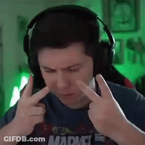 A Man Wearing Headphones Is Covering His Ears With His Hands While Making A Funny Face . GIF