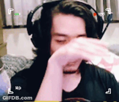 A Man Wearing Headphones Is Covering His Face GIF