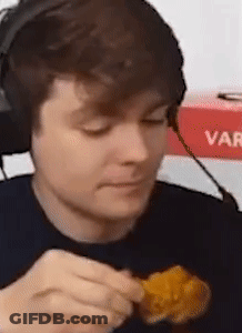A Man Wearing Headphones Is Eating Chicken Nuggets . GIF
