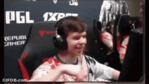 A Man Wearing Headphones Is Giving A Fist Bump GIF