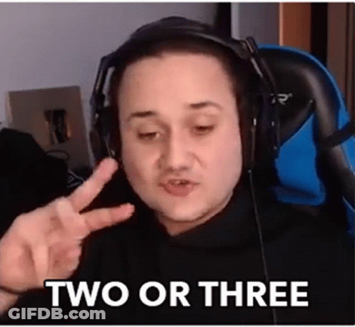 A Man Wearing Headphones Is Giving A Peace Sign While Sitting In A Chair . GIF