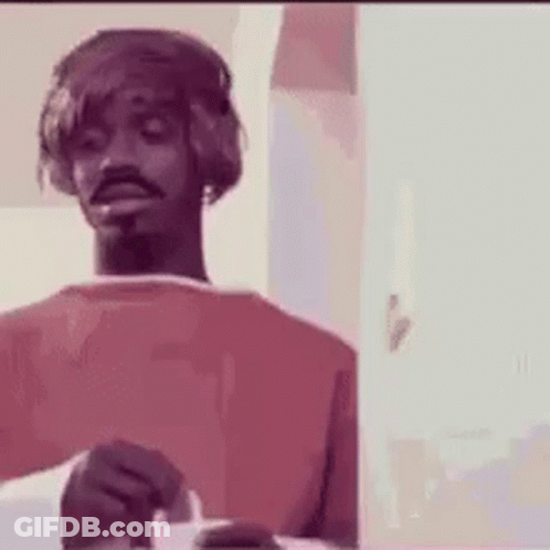 A Man Wearing Headphones Is Holding A Cigarette In His Hand . GIF