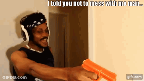 A Man Wearing Headphones Is Holding A Gun And Says " I Told You Not To Mess With Me Man ... " GIF