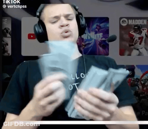 A Man Wearing Headphones Is Holding A Stack Of Money In His Hands GIF