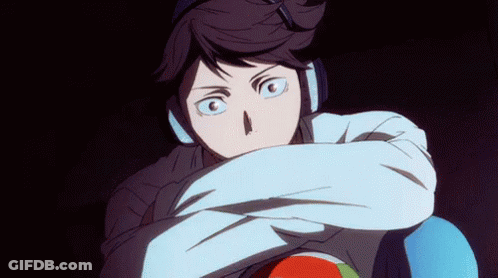 A Man Wearing Headphones Is Holding A Volleyball In His Hands . GIF