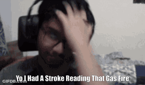 A Man Wearing Headphones Is Holding His Head And Says `` Yo I Had A Stroke Reading That Gas Fire '' GIF