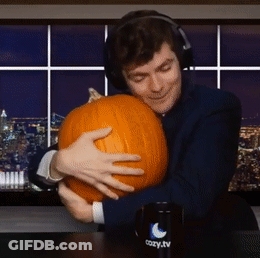 A Man Wearing Headphones Is Hugging A Pumpkin In Front Of A Cozy Tv Mug GIF
