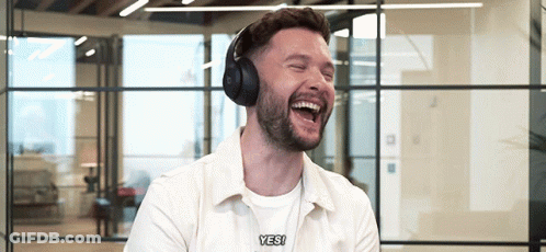 A Man Wearing Headphones Is Laughing And Saying " Yes " GIF